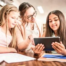 3 Mädchen in der Bibliothek mit e-book