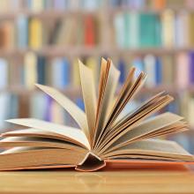Offenes Buch vor Bücherregalen