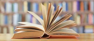 Offenes Buch vor Bücherregalen